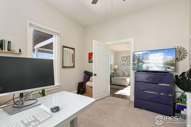 carpeted office space with ceiling fan