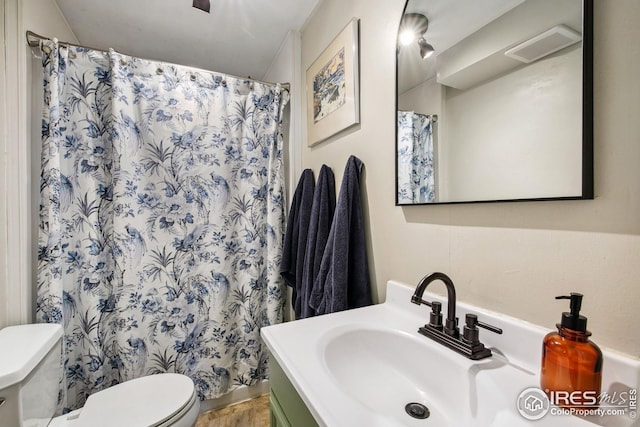 bathroom featuring curtained shower, toilet, and vanity