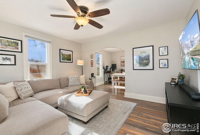 living room with ceiling fan and dark hardwood / wood-style flooring