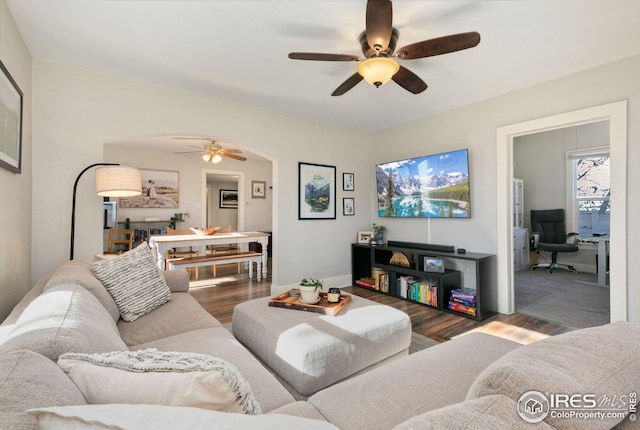 living room featuring ceiling fan and dark hardwood / wood-style floors