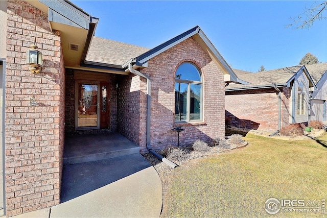 doorway to property featuring a lawn