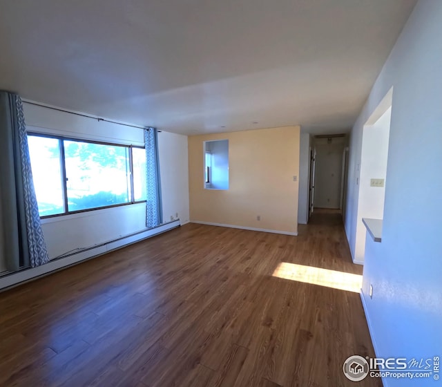 unfurnished room featuring hardwood / wood-style flooring and a baseboard radiator