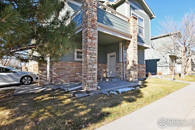 view of front of house featuring a balcony and a front yard