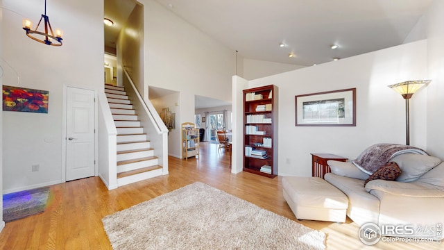 interior space with a towering ceiling, light hardwood / wood-style flooring, and a chandelier