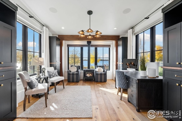 sitting room featuring a wood stove and light wood-style flooring