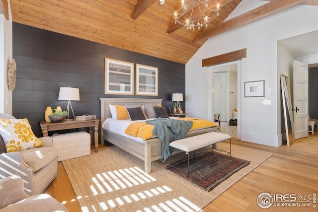 bedroom featuring baseboards, wood ceiling, wood finished floors, beamed ceiling, and an inviting chandelier