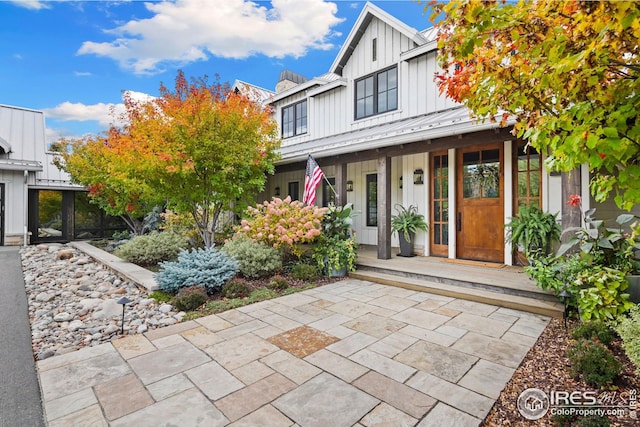 view of front of home featuring board and batten siding, a standing seam roof, a porch, and metal roof