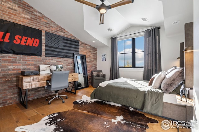 bedroom featuring brick wall, visible vents, vaulted ceiling, and hardwood / wood-style floors