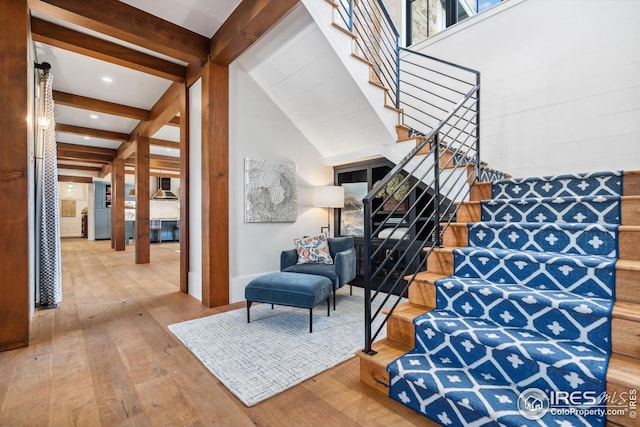 stairway with vaulted ceiling with beams and wood-type flooring