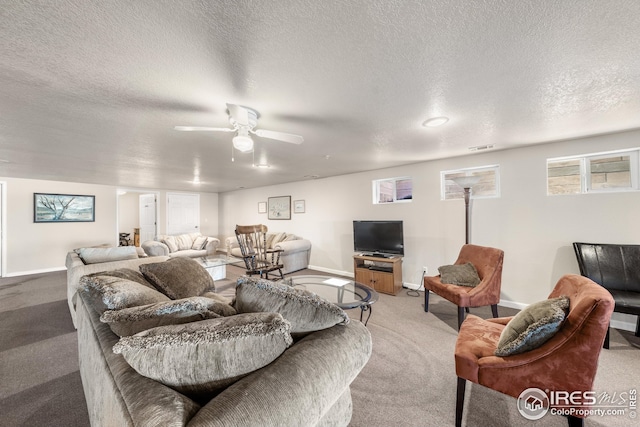 living room with a textured ceiling, ceiling fan, and carpet