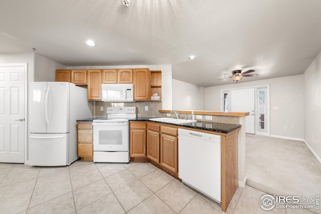 kitchen with white appliances, light carpet, dark stone countertops, sink, and ceiling fan