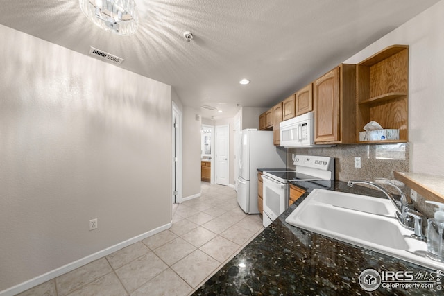 kitchen featuring white appliances, a textured ceiling, sink, backsplash, and light tile patterned flooring