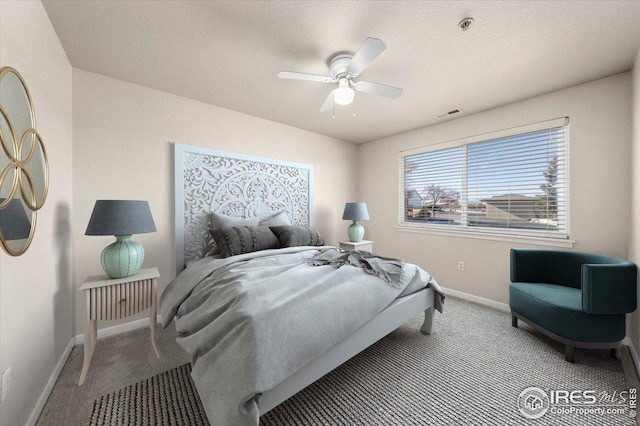 bedroom featuring a textured ceiling, ceiling fan, and light colored carpet