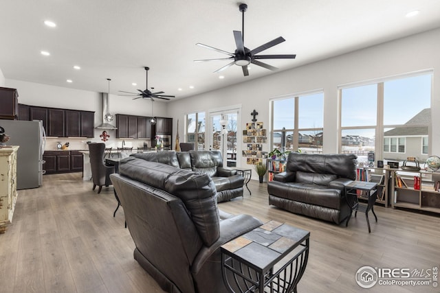 living room with ceiling fan and light wood-type flooring