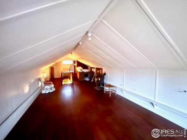 additional living space with vaulted ceiling and wood finished floors