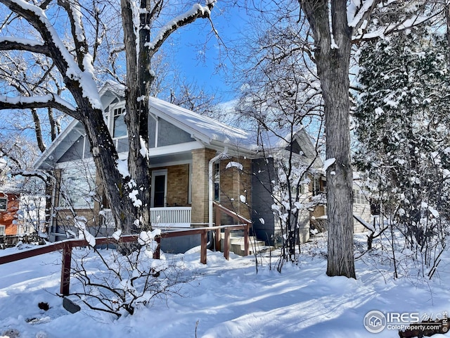 view of front of house with a garage, covered porch, and brick siding