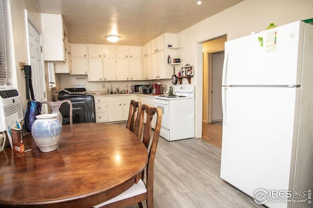 kitchen featuring light wood-type flooring, white cabinets, washer / clothes dryer, and white appliances