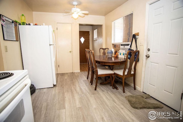 dining area with ceiling fan, cooling unit, and light hardwood / wood-style flooring