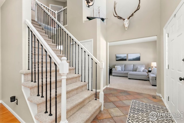 foyer with a high ceiling and carpet flooring