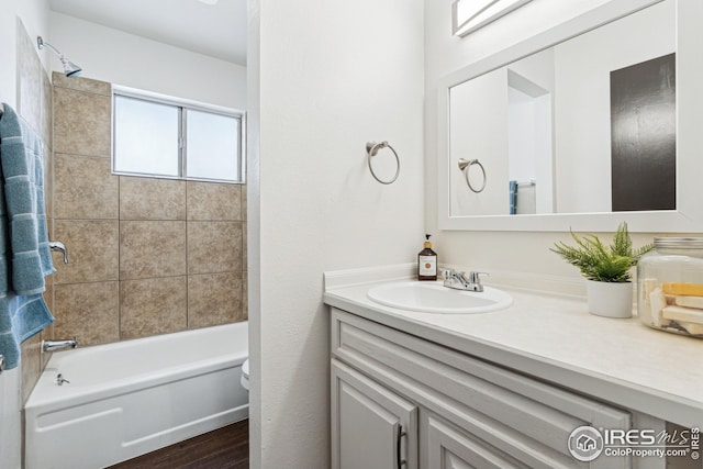 full bathroom with tiled shower / bath combo, vanity, and toilet