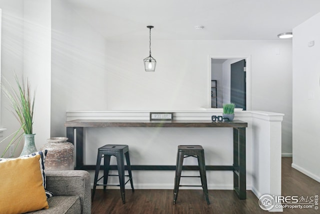 bar featuring dark hardwood / wood-style floors and decorative light fixtures