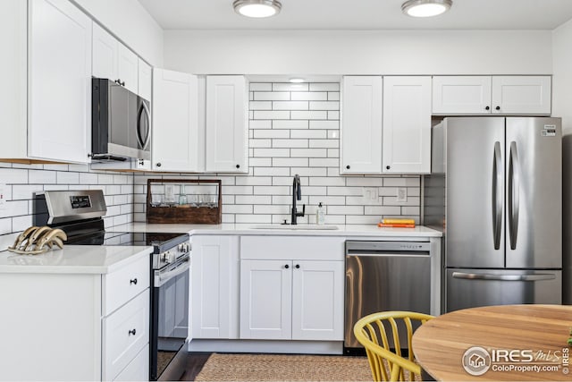 kitchen with appliances with stainless steel finishes, sink, and white cabinets