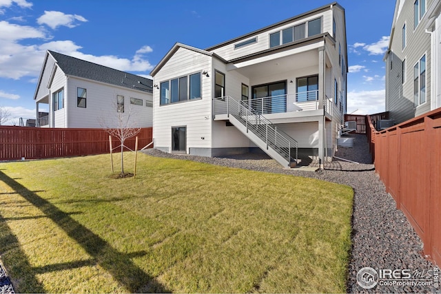 back of house with a lawn, stairs, and a fenced backyard