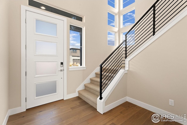 foyer featuring dark wood-style floors, stairs, and baseboards