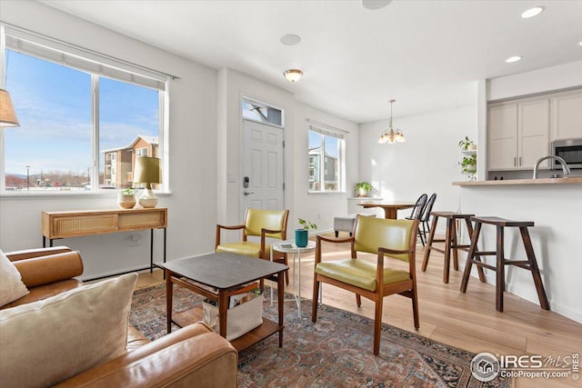 living room featuring a chandelier, light hardwood / wood-style flooring, and a wealth of natural light