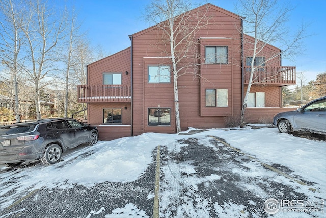 snow covered property featuring a balcony