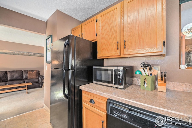 kitchen with black appliances, a textured ceiling, and light carpet