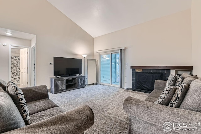 carpeted living room featuring a tile fireplace and high vaulted ceiling