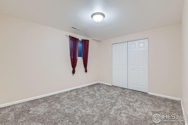 unfurnished bedroom featuring carpet and a closet