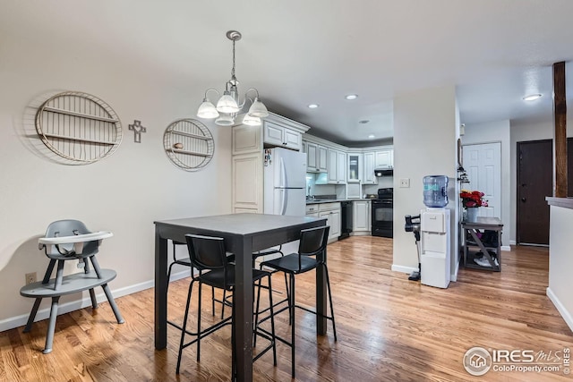 dining area featuring light hardwood / wood-style floors and a chandelier