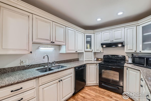 kitchen featuring sink, white cabinets, and black appliances