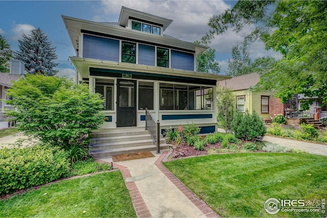 view of front of home featuring a front yard and a sunroom