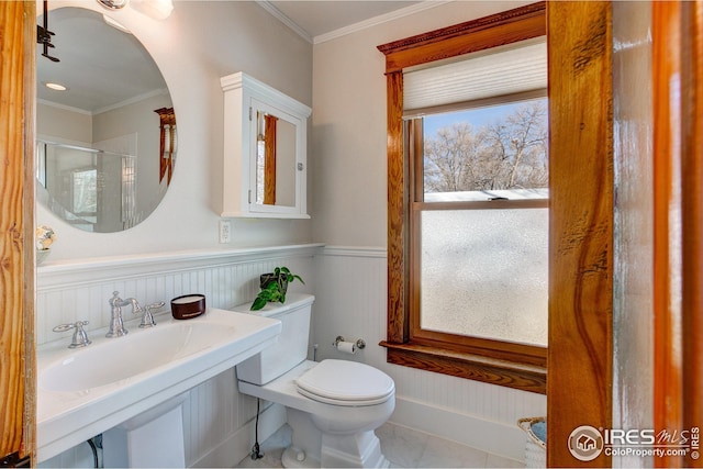 bathroom featuring a shower with door, toilet, and ornamental molding