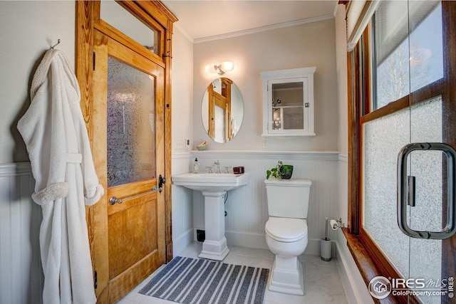 bathroom featuring toilet, tile patterned floors, and crown molding