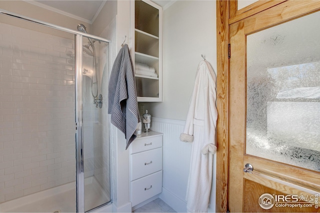 bathroom with crown molding and a shower with door