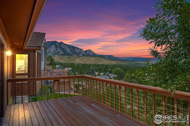 deck at dusk featuring a mountain view