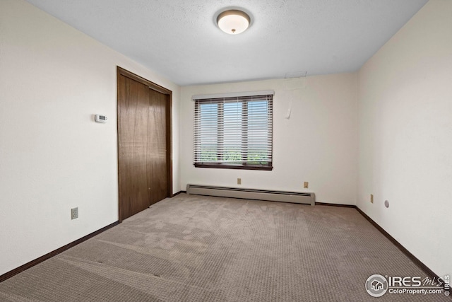 unfurnished bedroom with light carpet, a baseboard radiator, and a closet