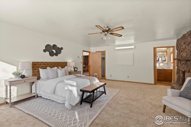carpeted bedroom featuring ceiling fan and ensuite bathroom