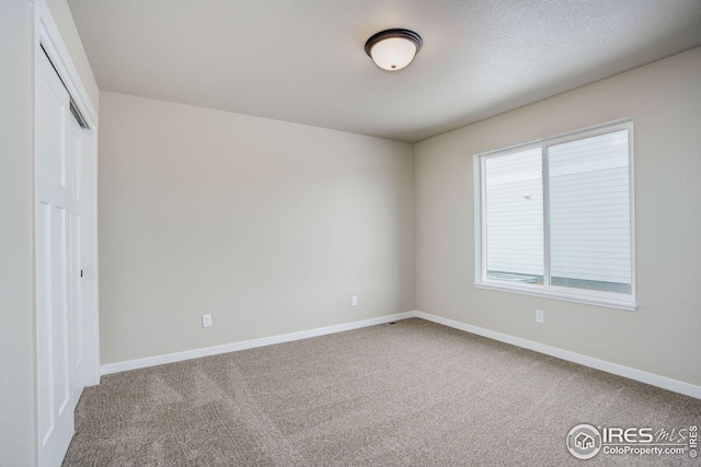 empty room with baseboards and carpet flooring