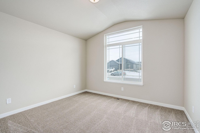 unfurnished room with light carpet, visible vents, baseboards, and lofted ceiling