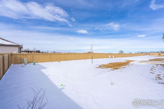 yard layered in snow with fence