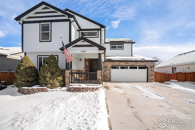 view of front of home featuring a garage, fence, and brick siding