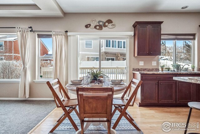 dining area with light hardwood / wood-style floors and sink