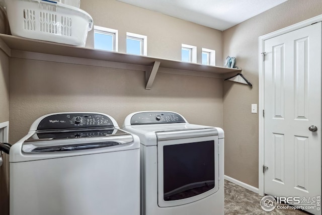 clothes washing area with plenty of natural light and washer and clothes dryer