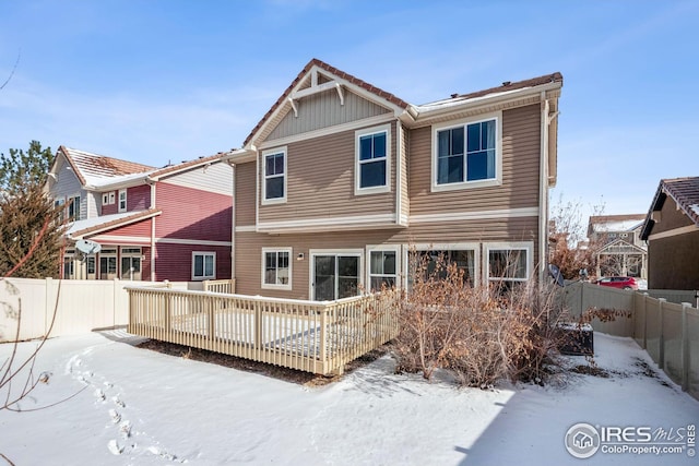 snow covered house with a wooden deck