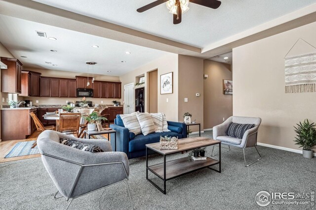 carpeted living room featuring ceiling fan